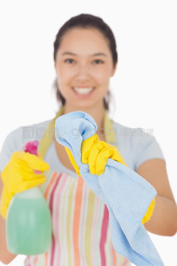 快乐的女人用布和喷雾瓶清洁窗户